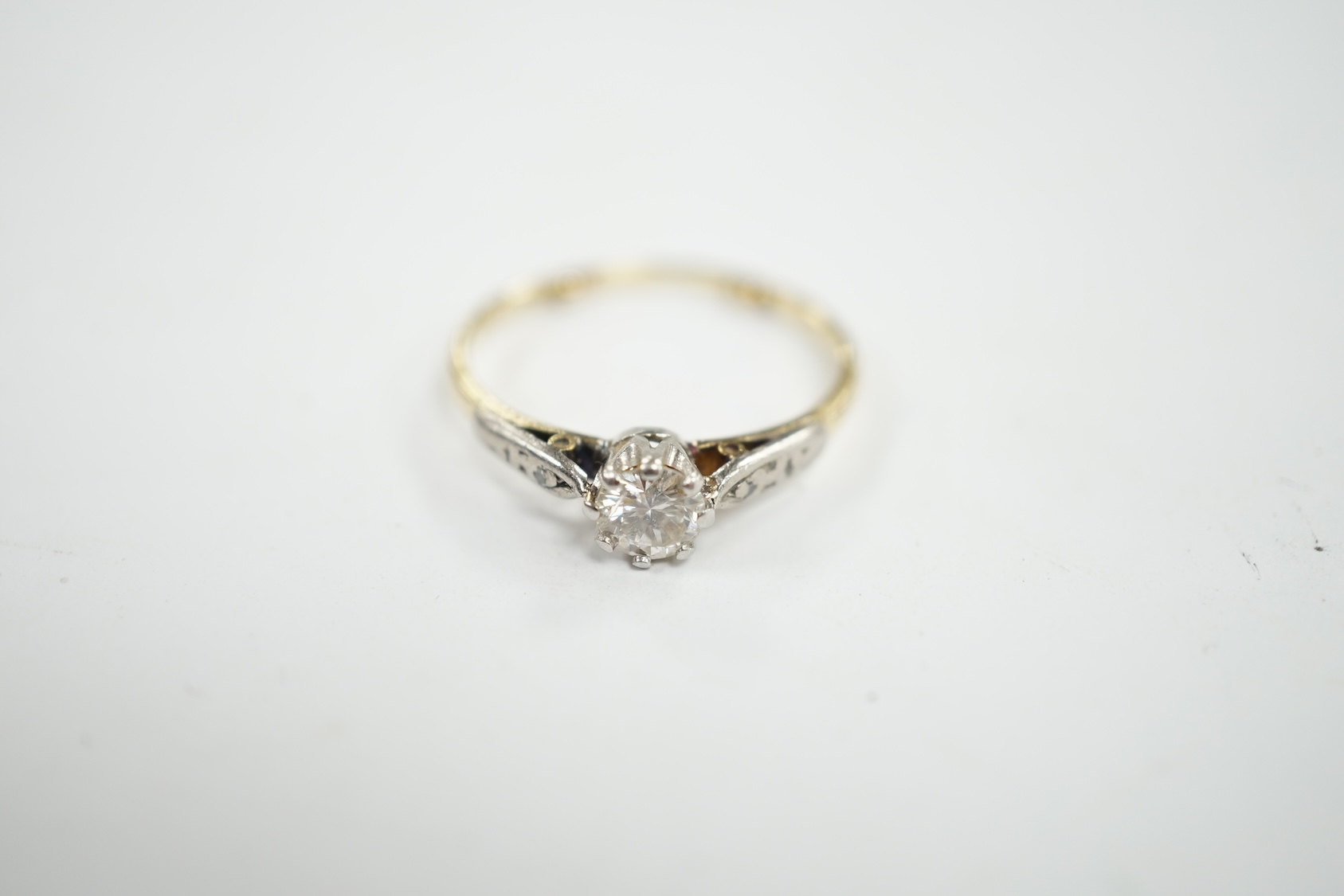 An 18ct, plat and single stone diamond set ring, with diamond chip set shoulders, size O/P, gross weight 2.5 grams. Condition - poor to fair